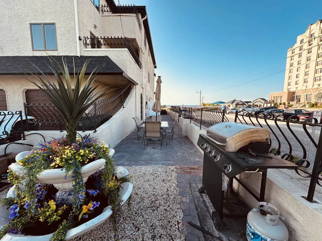 Outdoor grill in front garden with dining table on gated oceanfront patio