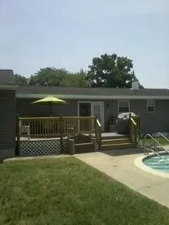 The deck has a patio set with umbrella and gas grill.