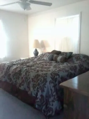 Another view of the Master bedroom. It has a ceiling fan with r