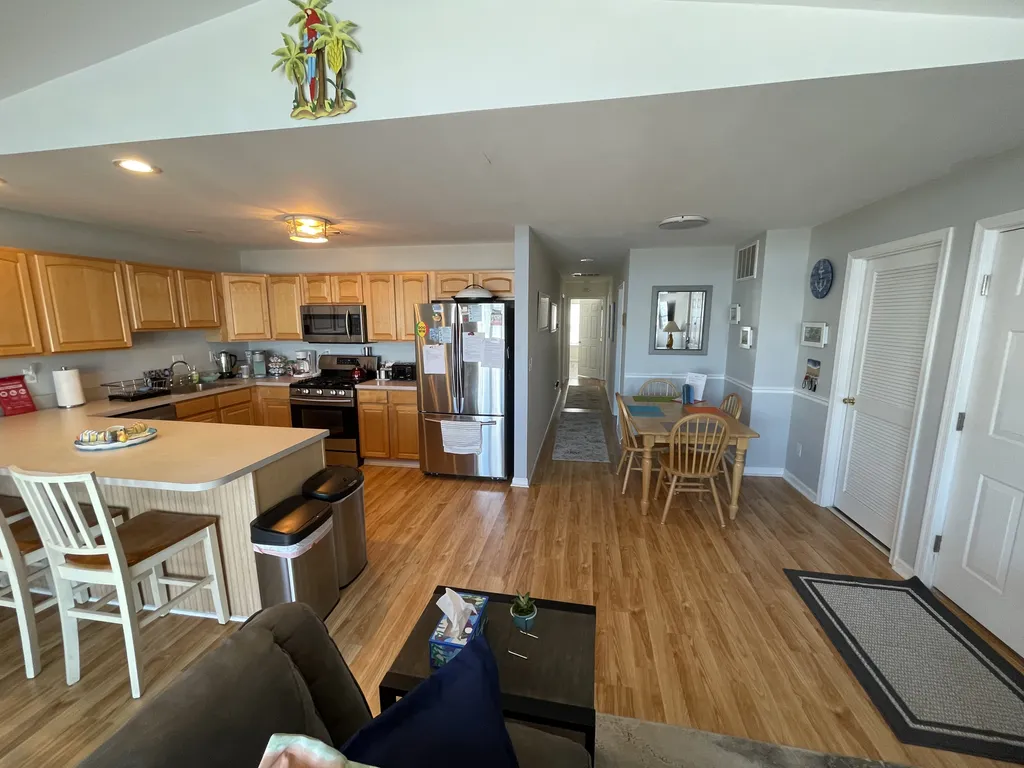View from sofa towards kitchen area, towards the bedrooms with additional table and chairs 