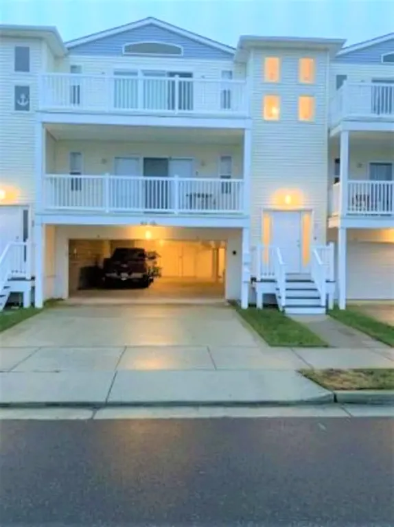 Front of building? Stairs to the right of the garage 
