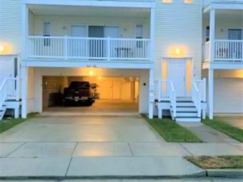 Front of building? Stairs to the right of the garage 