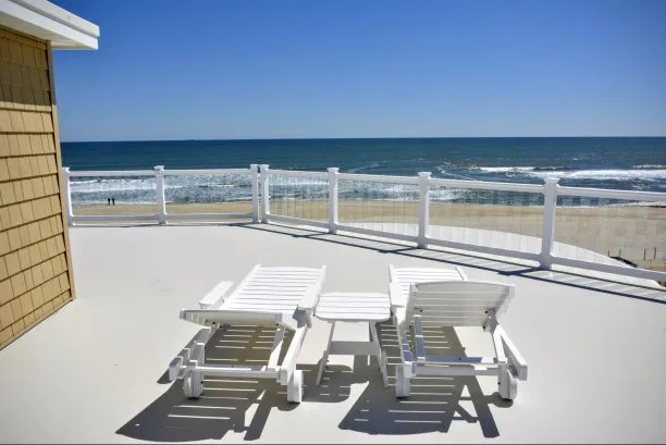 Roof top deck with four chase lounge and large square dining table