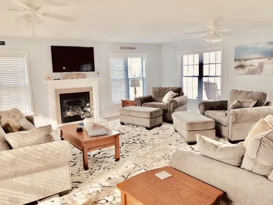 Sun-soaked 625sf spacious living room with memory foam queen sleeper, dresser, fireplace, and direct access to bay-view deck.