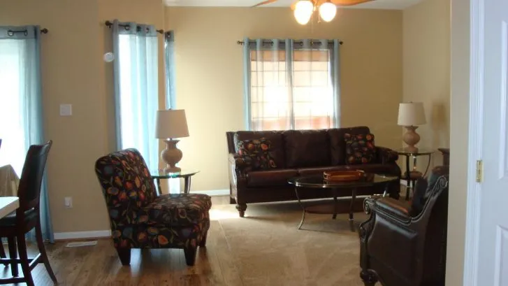 Comfortable living area with leather furniture and new hardwood flooring.