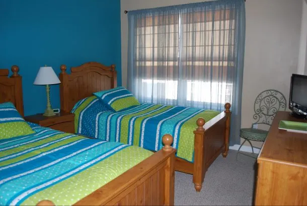Bedroom #3 with TV/DVD Player.  Window looks out onto patio/pool area.