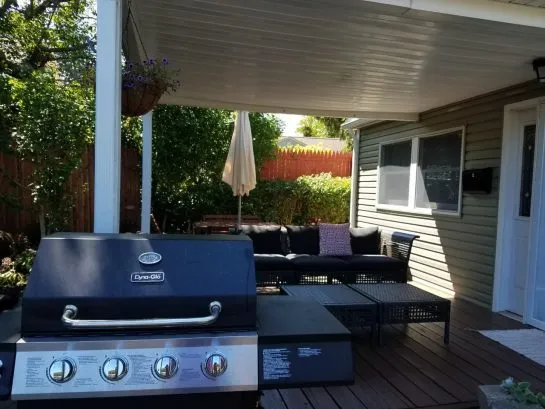 covered porch with seating and gas grill