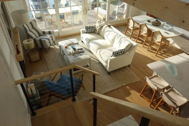 TV, sitting, and dining areas seen from stairs.  The long cushioned dining bench makes a nice extra sofa or reading nook.