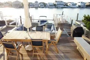Multi-level waterfront decks include dining area, lower lounge area with fireplace table, pier with umbrella pub table and gangway gate, and floating dock for swimming, boating, and daydreaming. 