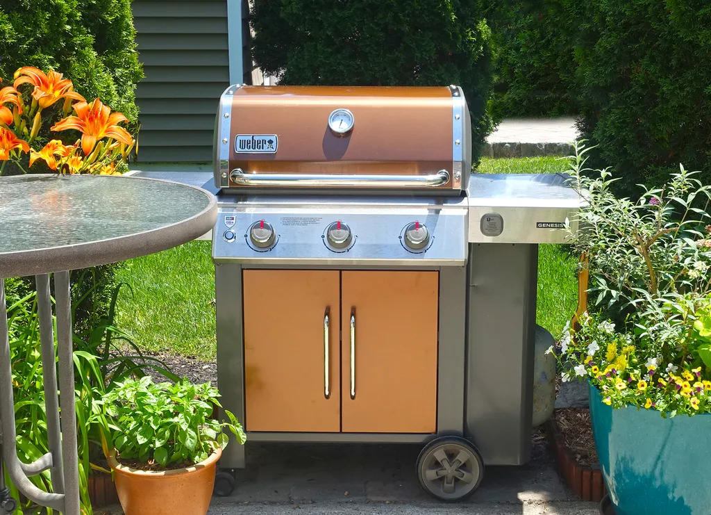 Weber gas grill with grilling tools.