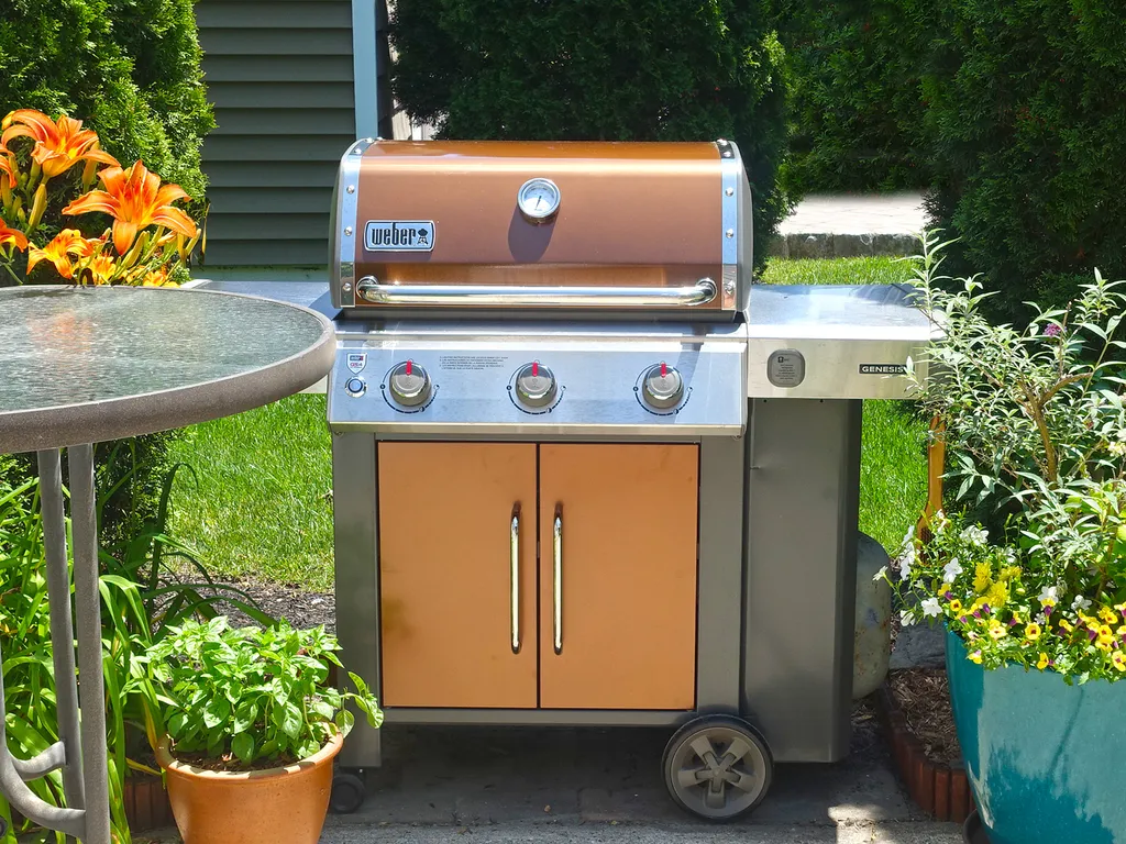 Weber gas grill with grilling tools.