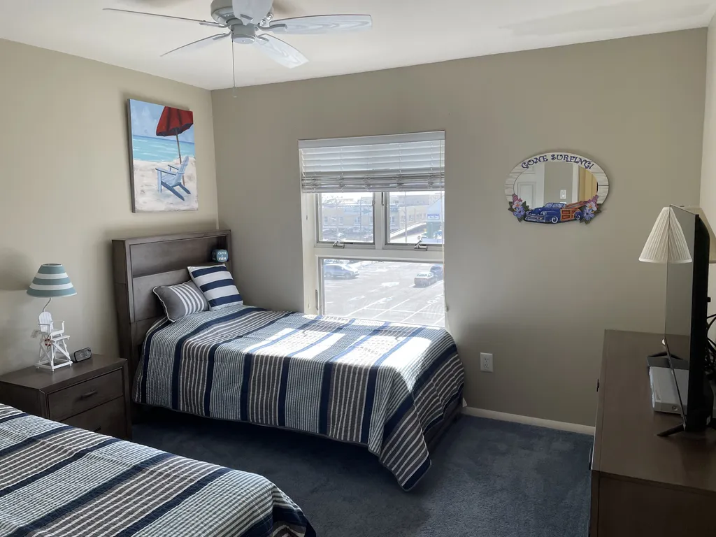 upstairs twin bedroom with tv, ceiling fan, ocean views