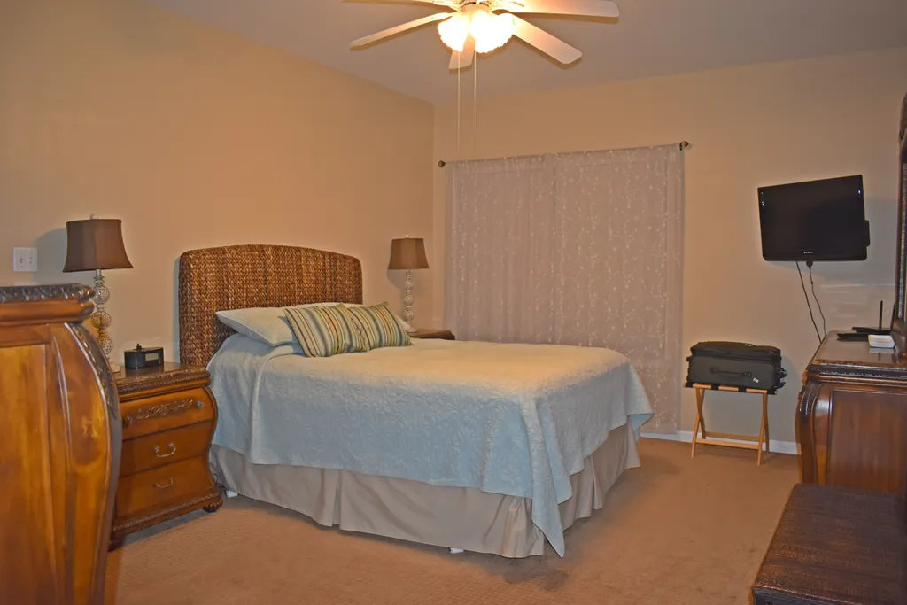 Main Bedroom with windows overlooking patio and pool area.