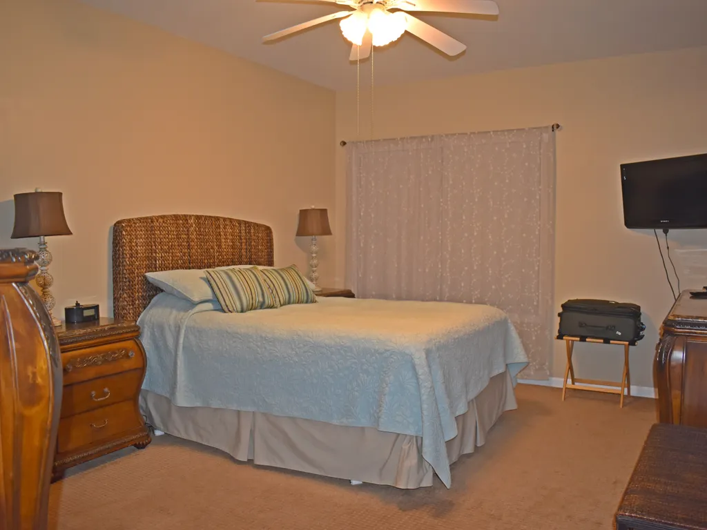 Main Bedroom with windows overlooking patio and pool area.