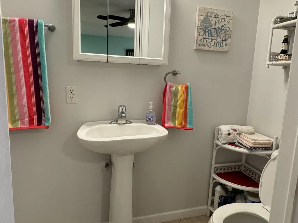 1st floor private full bathroom with pedestal sink, chair-height toilet, and walk-in shower.