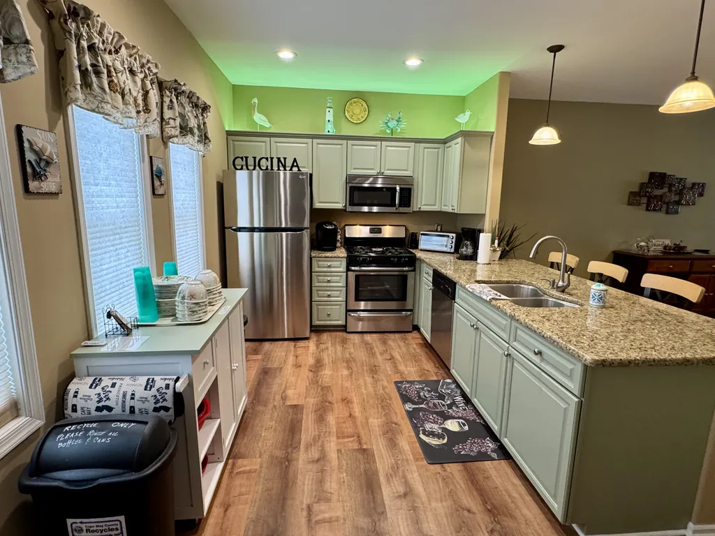 Kitchen with stainless steel refrigerator and automatic ice maker, range, dishwasher, microwave, and dual sinks with garbage disposal 