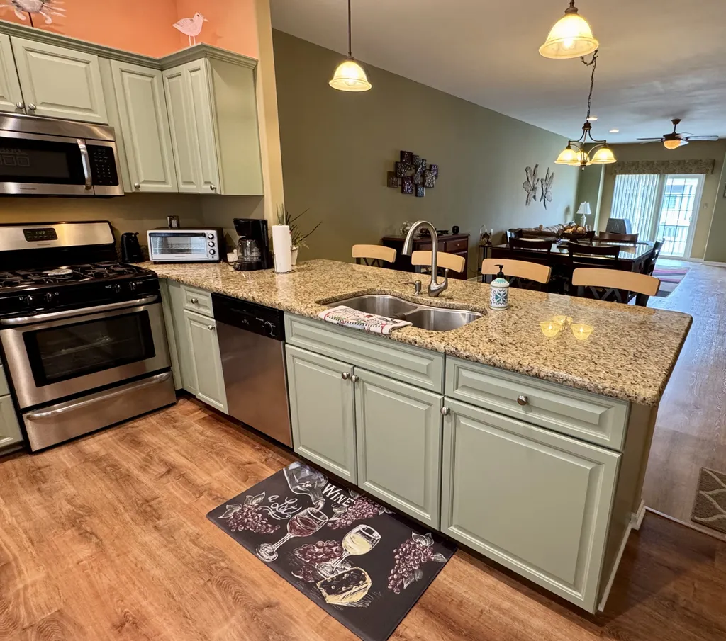 Granite countertop breakfast bar with dual sinks and garbage disposal.