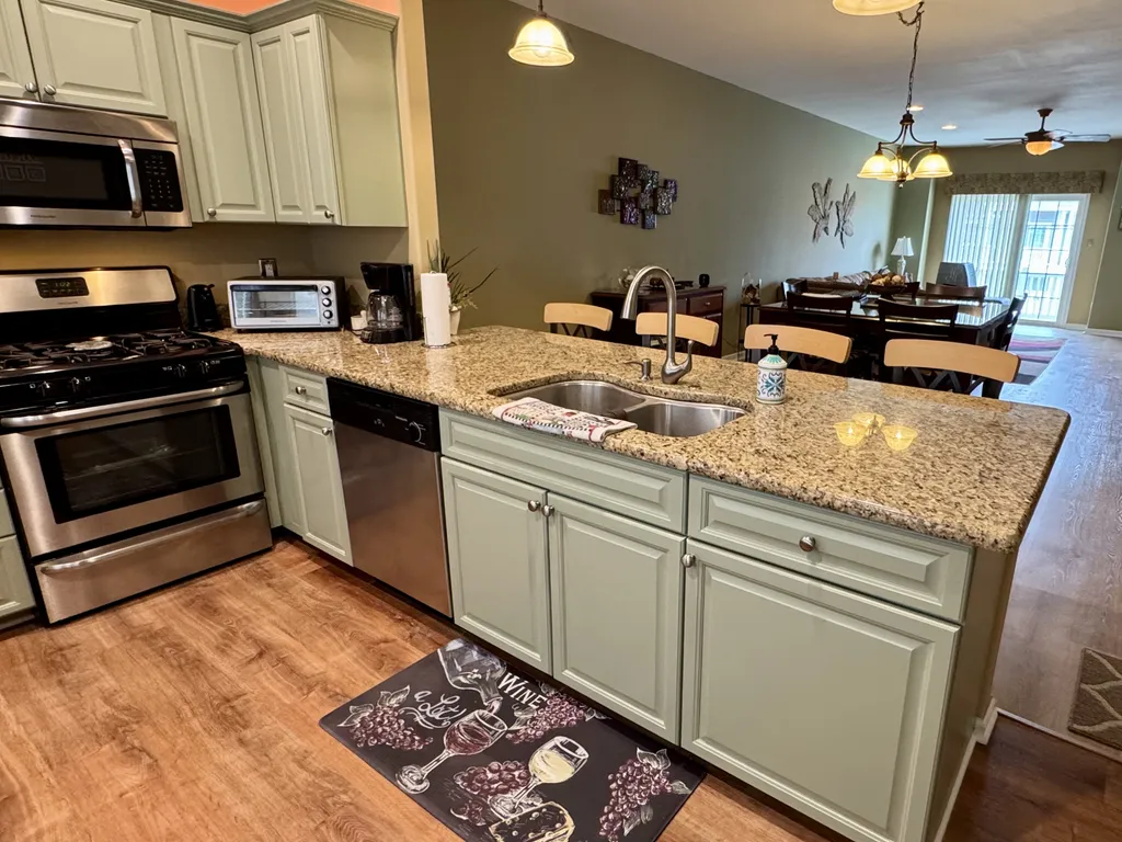Granite countertop breakfast bar with dual sinks and garbage disposal.