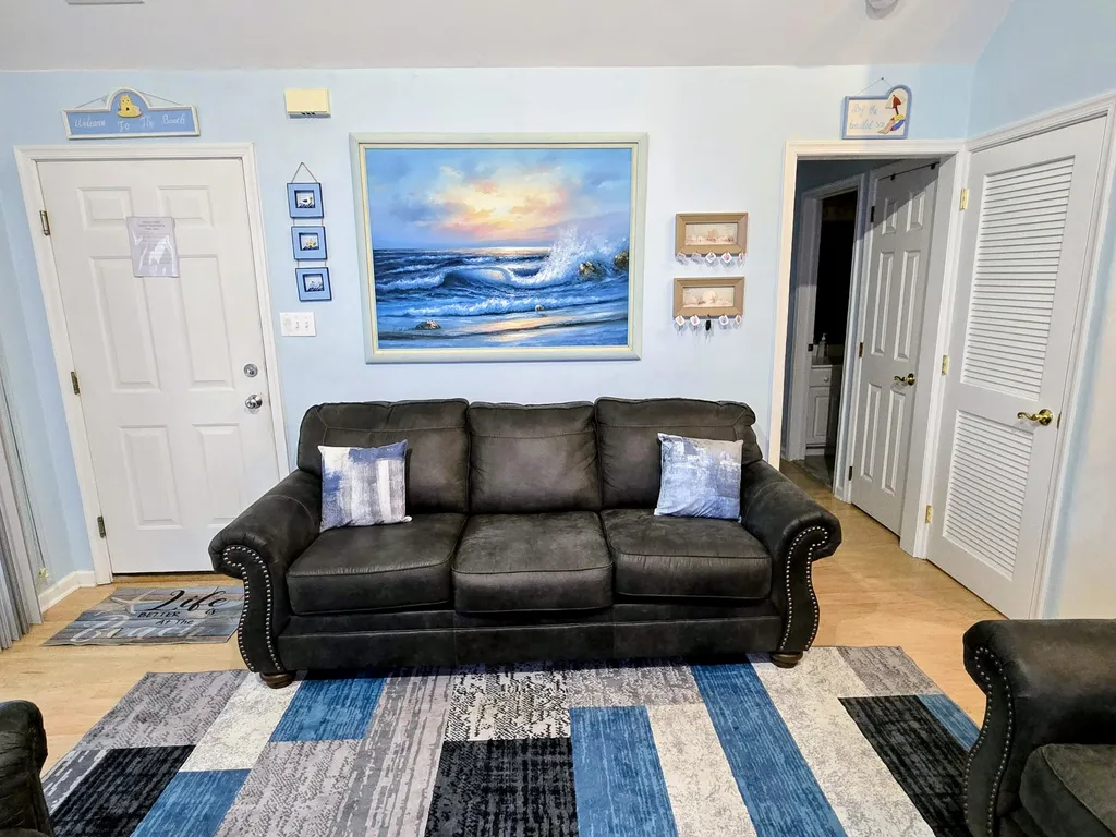 Living Room facing entry door and hallway to bedrooms and bathrooms
