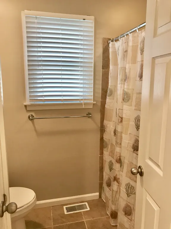 Main Bathroom with Quartz Counters and Tile Floor