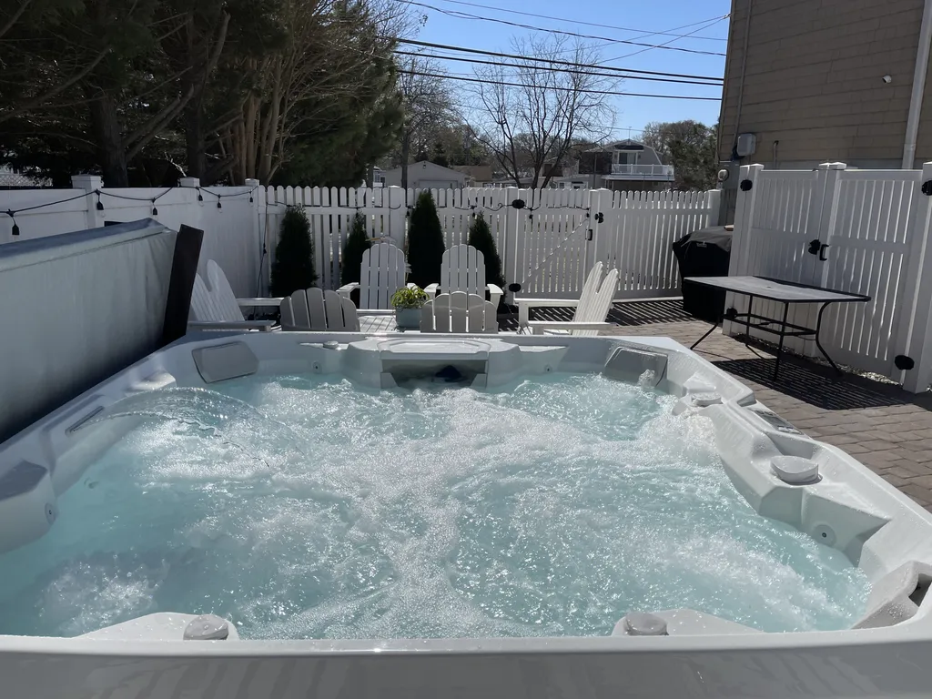 Hot tub oasis on newly paved private yard.  Equipped with lounge area and propane 6 burner grill