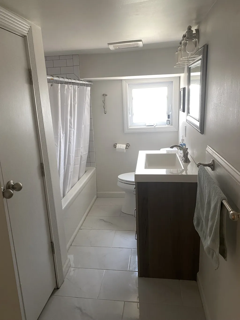 The apartment bath has a shower tub, as well as an updated sink and towel bars, plus a closet for additional storage