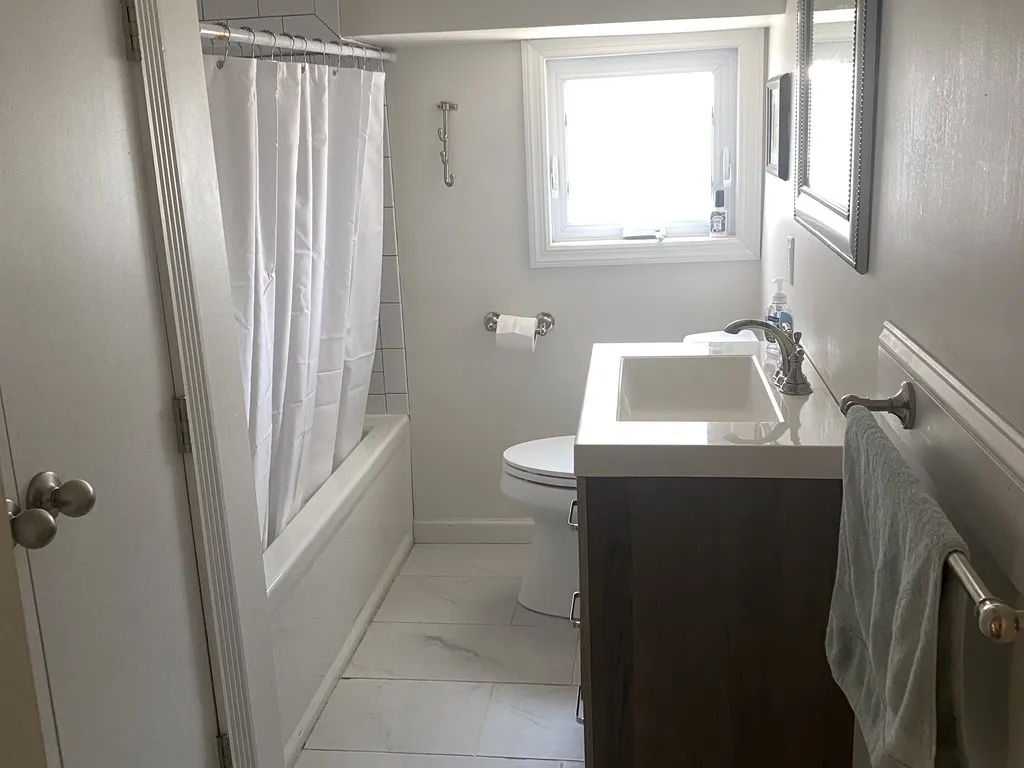 The apartment bath has a shower tub, as well as an updated sink and towel bars, plus a closet for additional storage