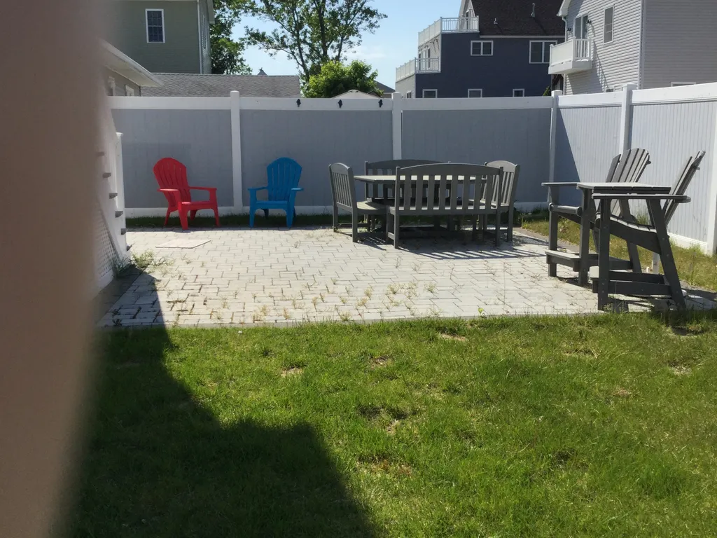 Sunny backyard with outdoor dining space &amp;amp; outdoor shower