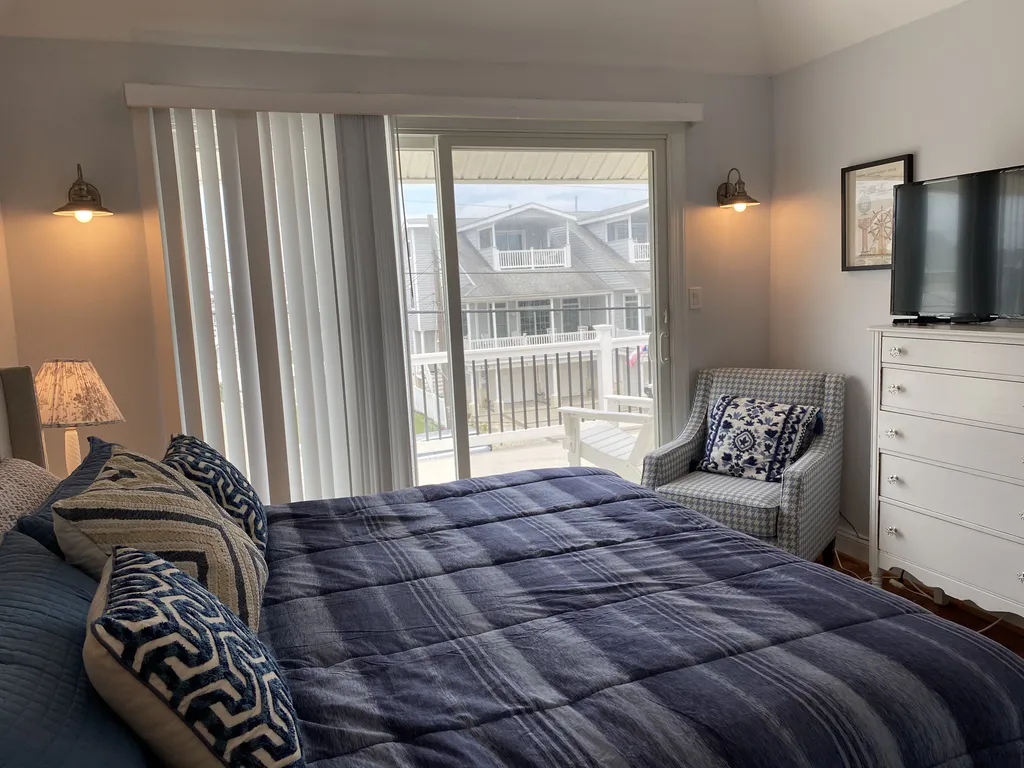 Primary bedroom and door to upper porch with views of the bay