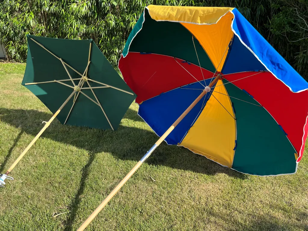 two options for beach umbrellas - the green is lighter weight, but does not cover as much, The multicolored one is heavier, but provides more coverage
