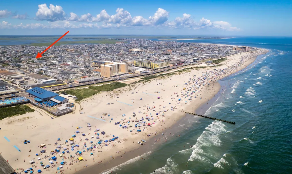Drone view of condo showing a beautiful summer day at the beach, arrow pointing to the condo unit