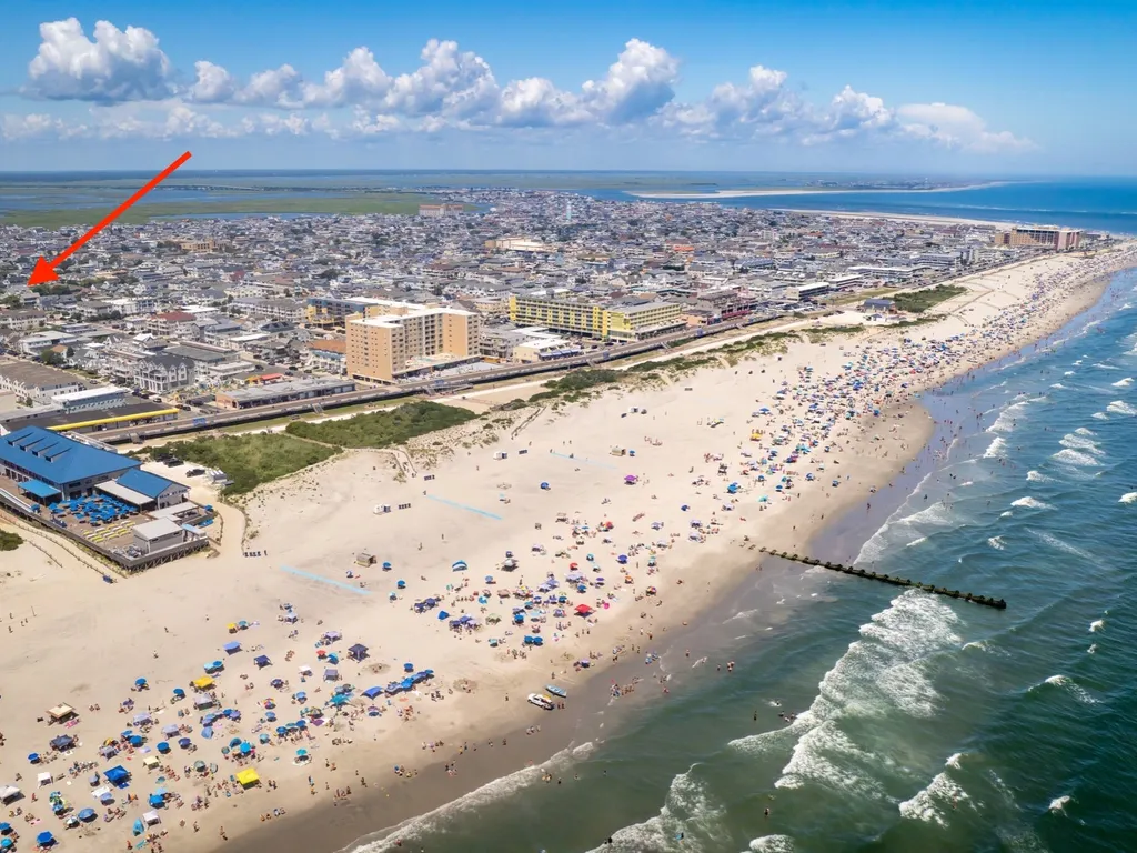 Drone view of condo showing a beautiful summer day at the beach, arrow pointing to the condo unit