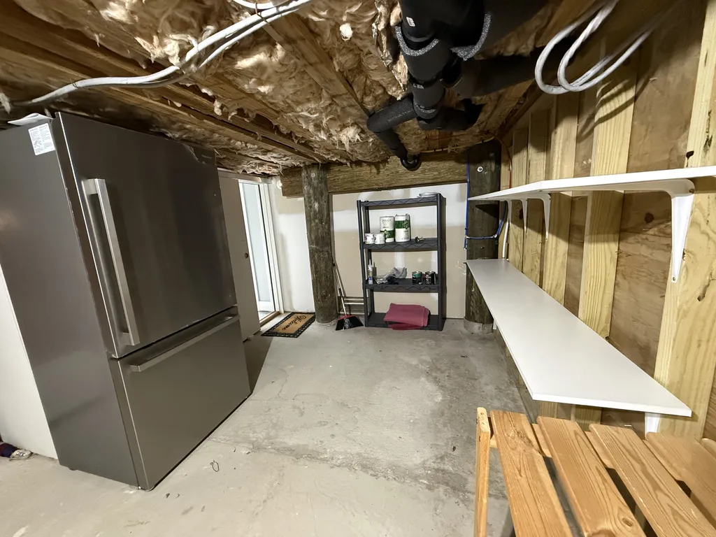 Dry storage and extra fridge next to elevator door at street level