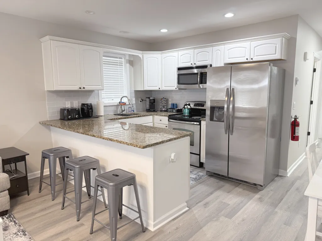Kitchen features fridge, stove, oven, microwave, dishwasher, toaster and kettle.