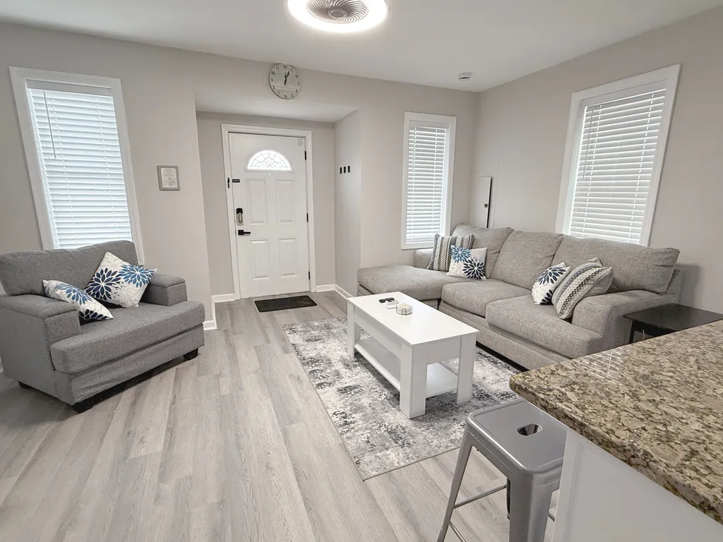 Sofa and over stuffed seat in living room with smart tv