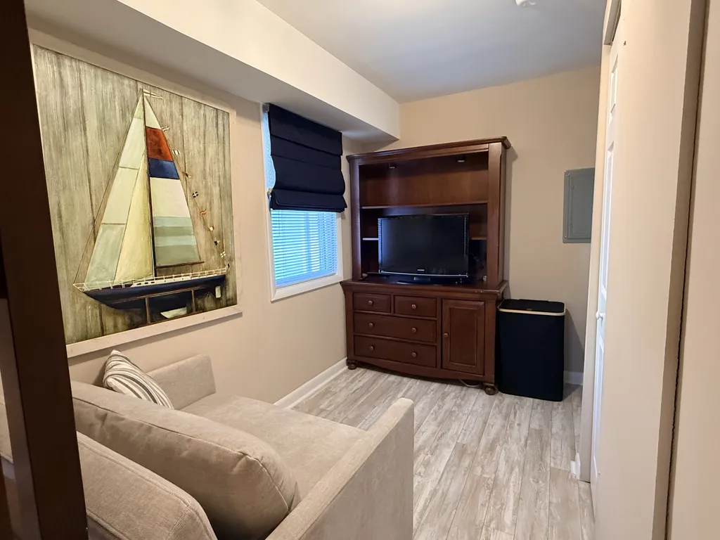 Seating area with oversized chair (converts to twin bed) in bedroom 