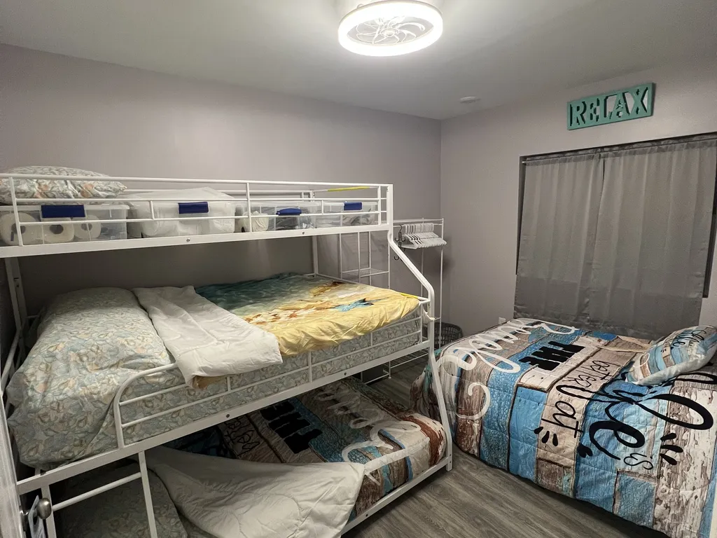 One queen bed and one bunk bed with queen and full mattress