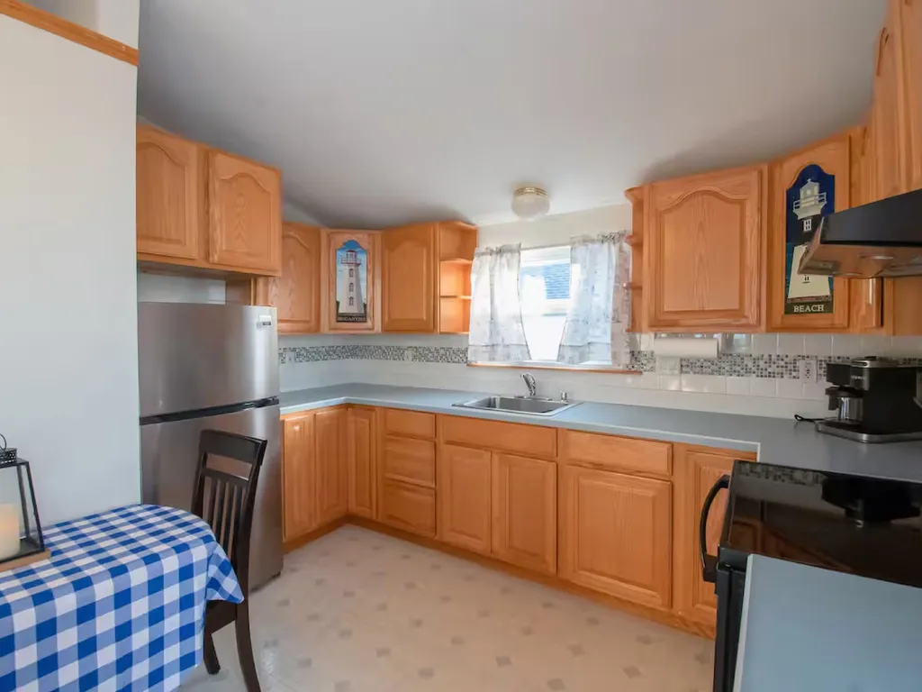 Kitchen with brand new refrigerator,stove. and Microwave. Space is equipped with dishes, silverware, pots, pans, utensils, and basic needs to prepare a great meal. This picture shows the space when the kitchen table is collapsed.