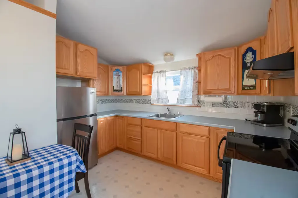 Kitchen with brand new refrigerator,stove. and Microwave. Space is equipped with dishes, silverware, pots, pans, utensils, and basic needs to prepare a great meal. This picture shows the space when the kitchen table is collapsed.