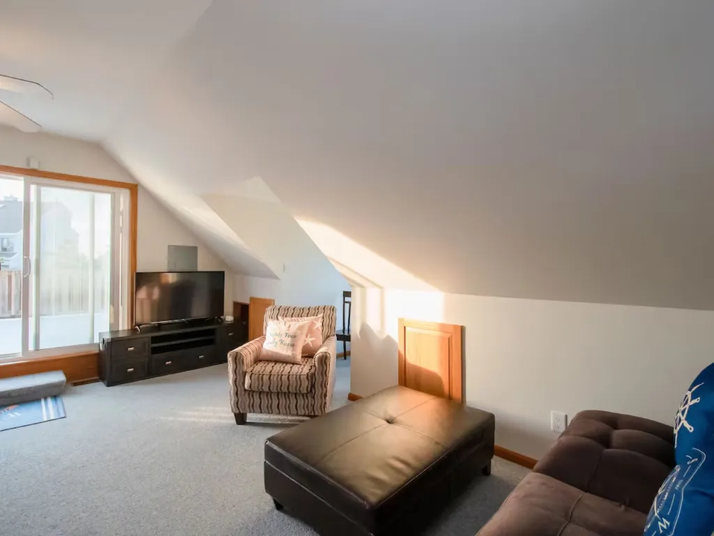 Living room with Smart Flat screen TV. Storage for luggage is behind brown door