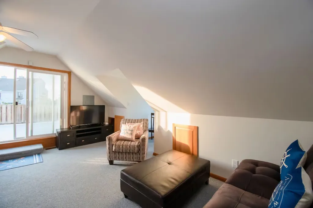 Living room with Smart Flat screen TV. Storage for luggage is behind brown door