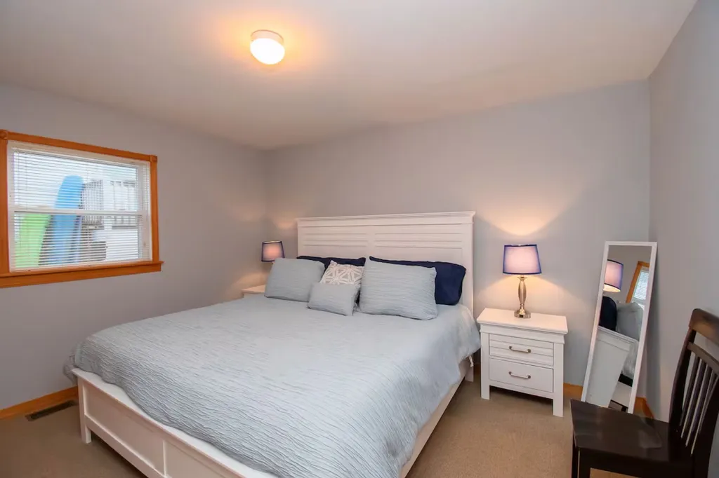 The beach-inspired primary bedroom is a serene retreat adorned with natural textures and soothing hues.