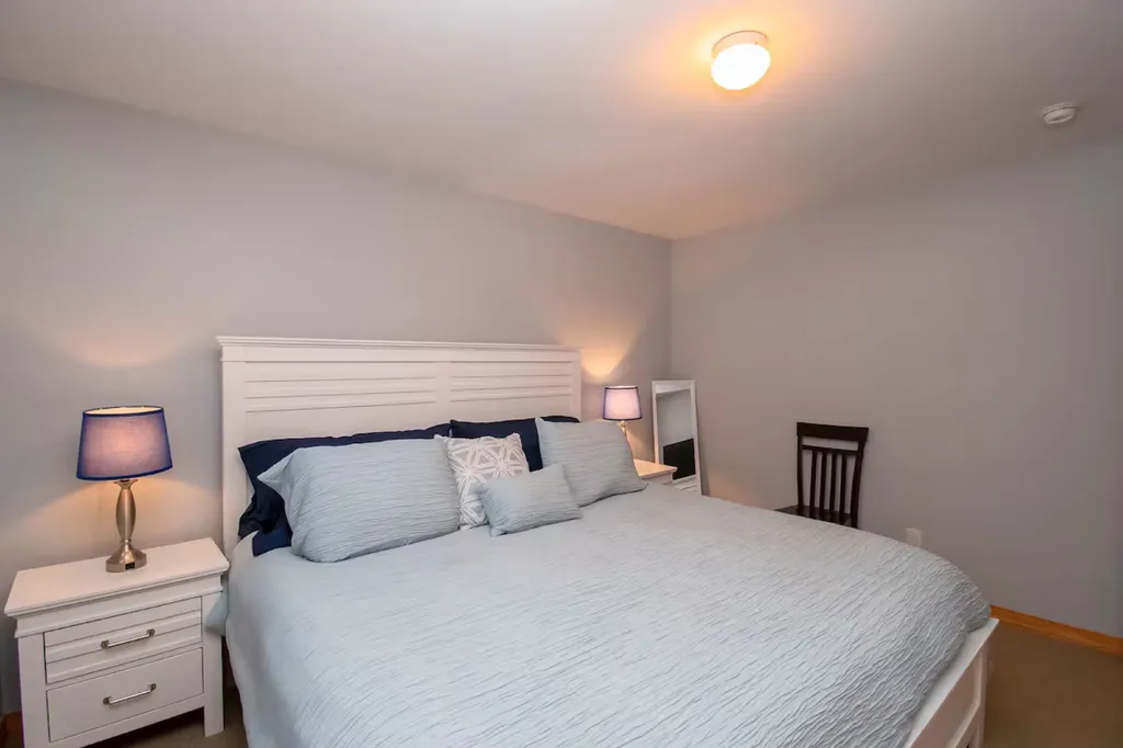 The primary bedroom boasts luxurious comfort with its spacious layout and a grand king-size bed that invites relaxation and restful nights.