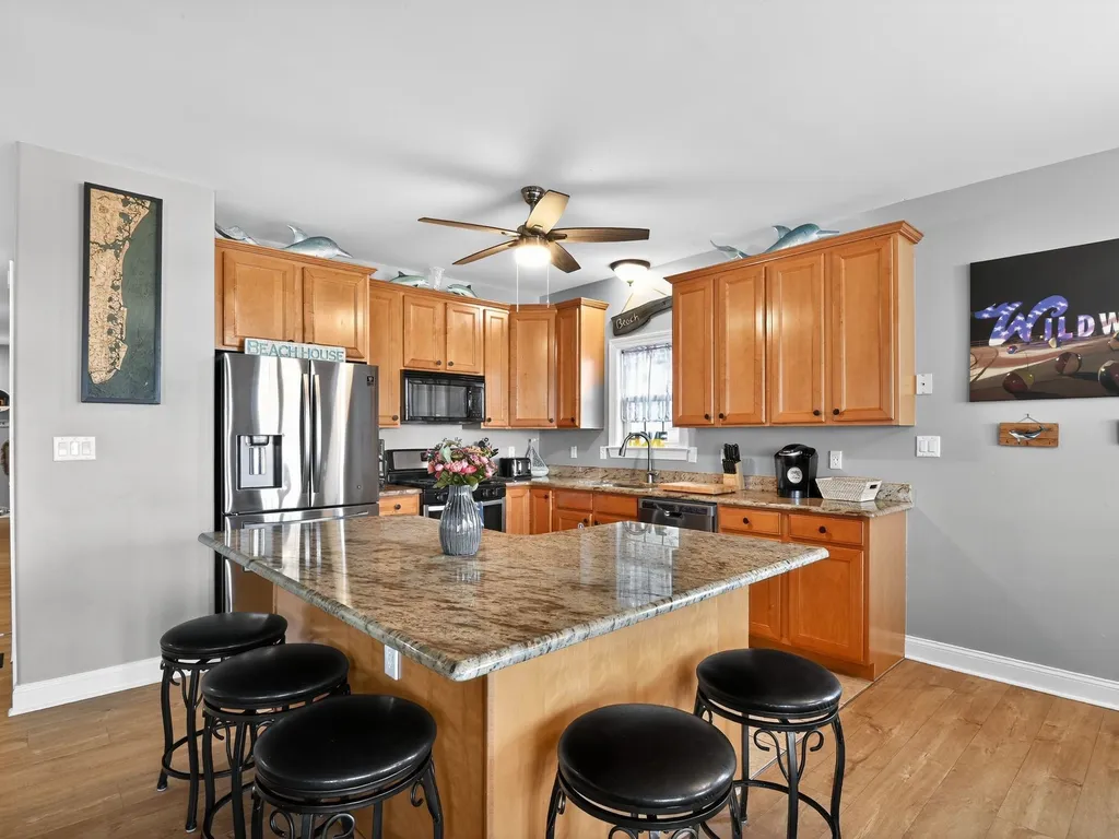 Spacious kitchen with bar seating, along with dining table. 