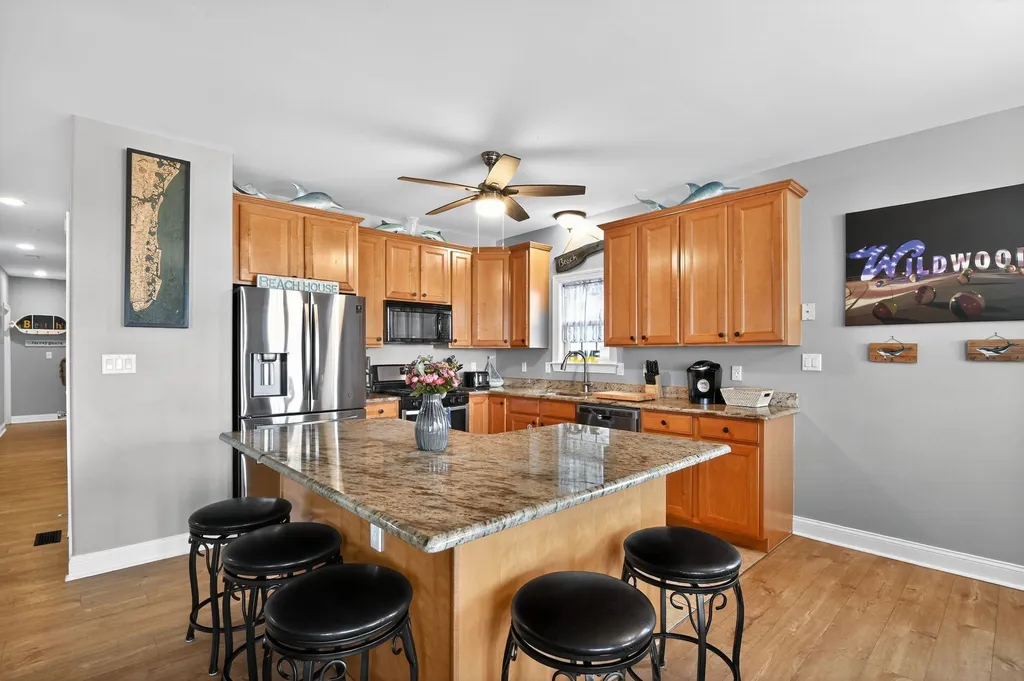 Spacious kitchen with bar seating, along with dining table. 