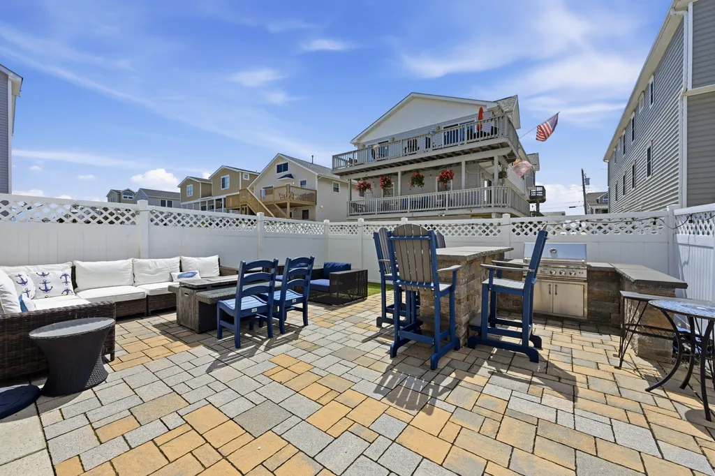 Enjoy a large fenced-in backyard with plenty of comfortable seating, a dining bar, and built-in BBQ grill.