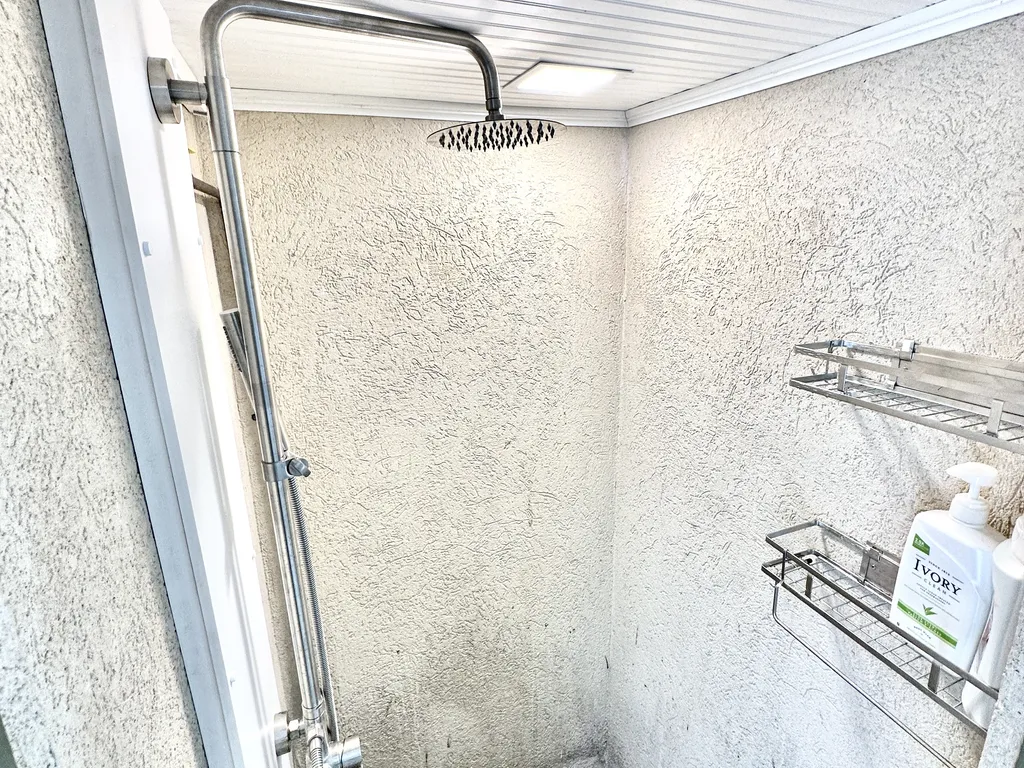 Outdoor shower with rain shower head, light, and locking door